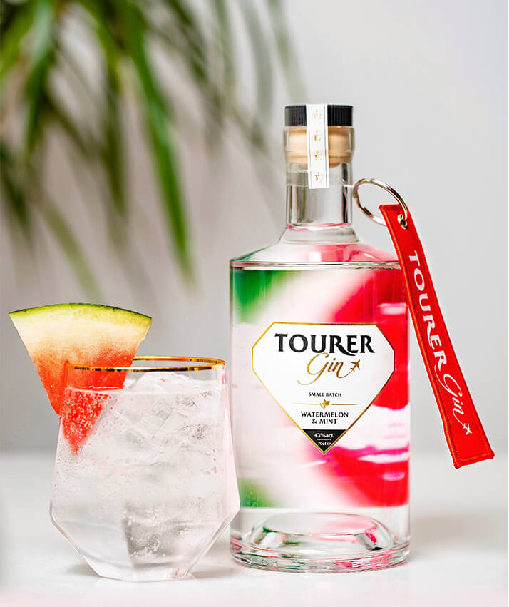 Watermelon gin by tourer gin served with tonic, watermelon and mint in a cocktail glass