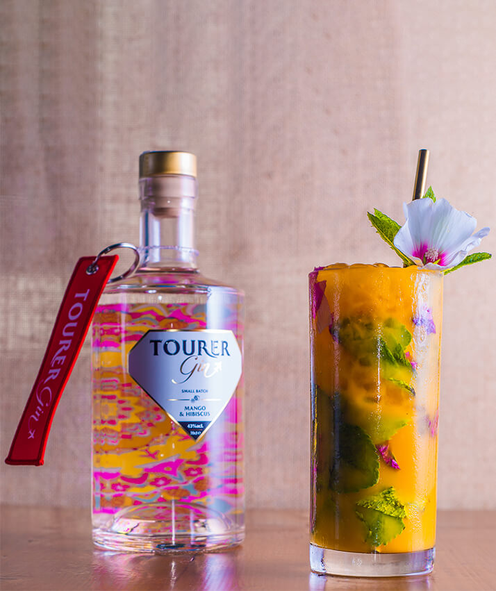 Tourer mango gin and mango mojito cocktail with hibiscus flower garnish